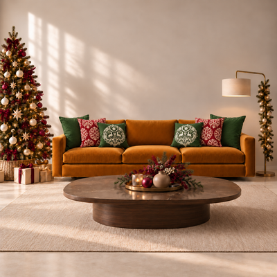 Cojines decorativos navideños Pyctorella en verde bosque y rojo burgundy, con estampados de renos y diseños ornamentales, sobre sofá mostaza en sala moderna con árbol de Navidad y decoración elegante.