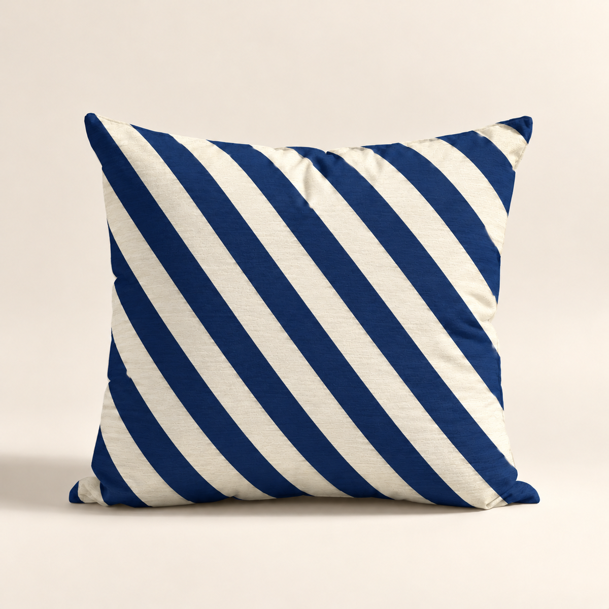 Cojin Navideño Blue Stripes con estampado de rayas diagonales azul y color marfil